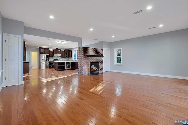 unfurnished living room with a fireplace and light hardwood / wood-style floors