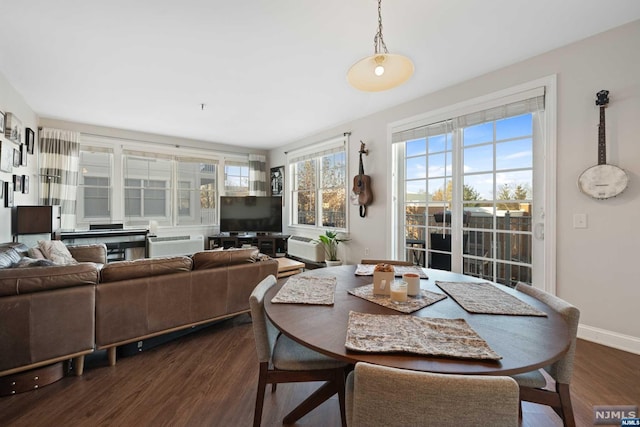 dining area featuring dark hardwood / wood-style flooring and a wall unit AC