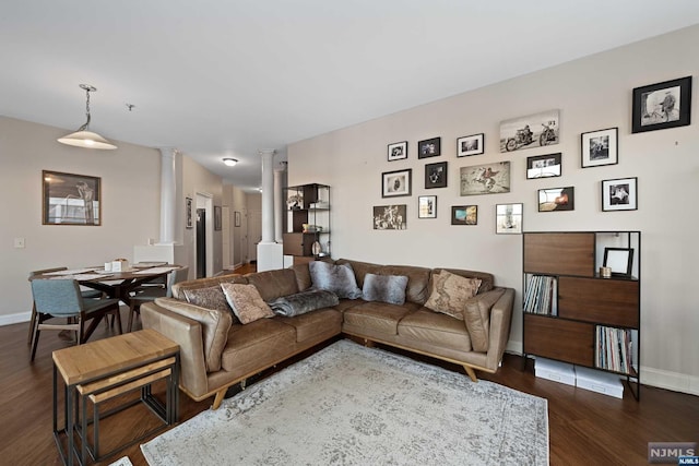 living room featuring dark hardwood / wood-style flooring and decorative columns