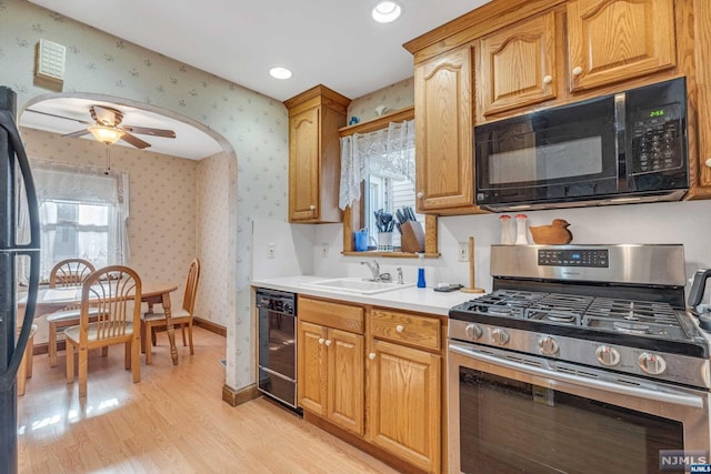 kitchen featuring sink, light wood-type flooring, ceiling fan, and black appliances