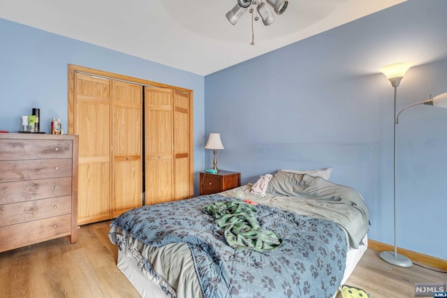 bedroom featuring ceiling fan, a closet, and light hardwood / wood-style floors