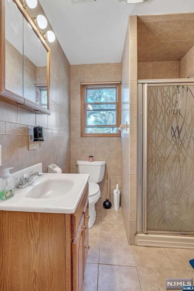 bathroom featuring tile patterned flooring, vanity, and tile walls