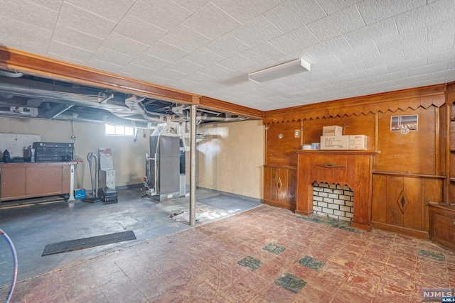 basement with heating unit and wood walls