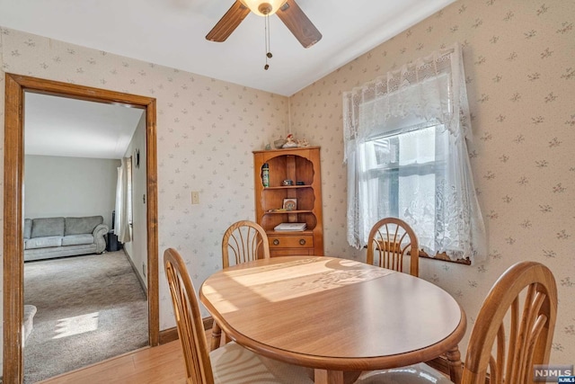 dining room featuring ceiling fan, wood-type flooring, and vaulted ceiling