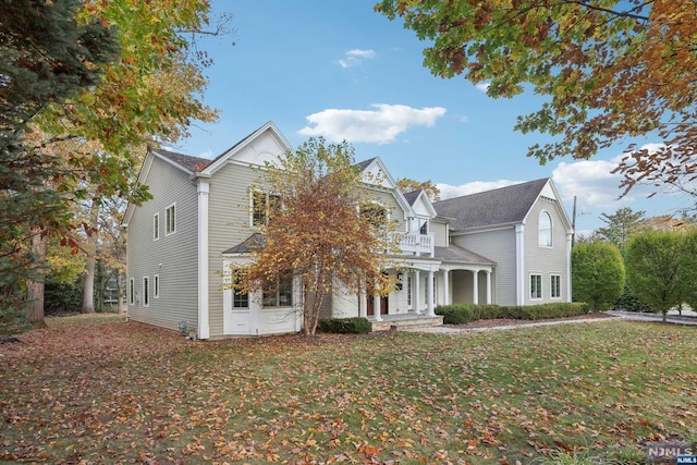 view of front of house with a front yard and a balcony