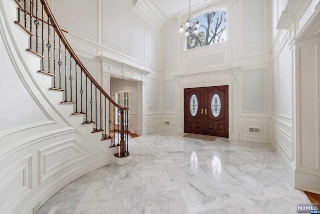 entrance foyer featuring a towering ceiling and a chandelier