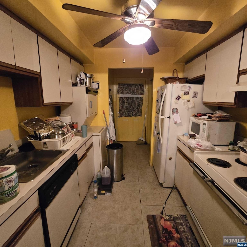 kitchen featuring white cabinets, white appliances, light tile patterned flooring, and sink