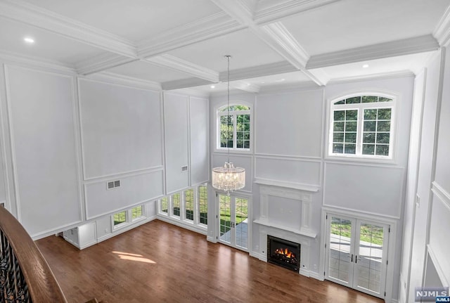 interior space with beam ceiling, french doors, dark wood-type flooring, coffered ceiling, and a notable chandelier