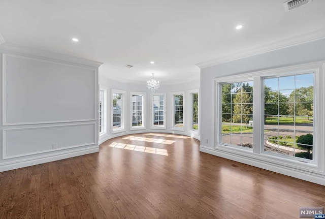 unfurnished living room featuring ornamental molding, hardwood / wood-style flooring, and a healthy amount of sunlight