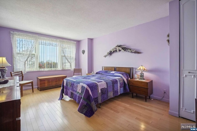 bedroom featuring light hardwood / wood-style flooring and a textured ceiling