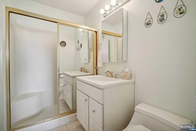 bathroom featuring a shower with shower door, a textured ceiling, and toilet