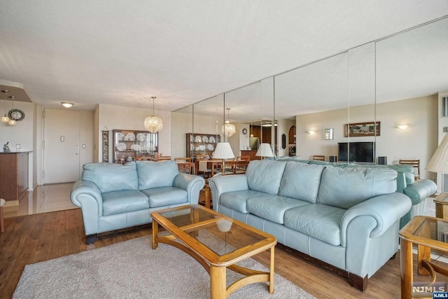 living room featuring hardwood / wood-style flooring, a textured ceiling, and a chandelier