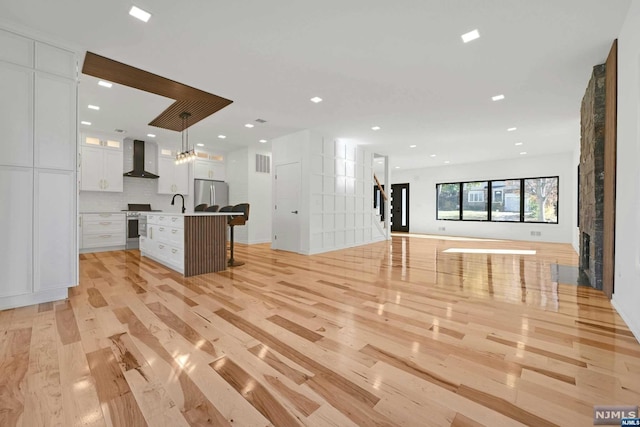 unfurnished living room with light wood-type flooring and sink