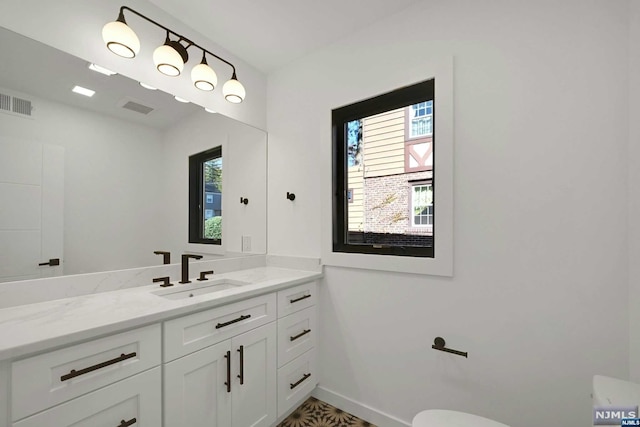 bathroom with vanity, toilet, and a wealth of natural light