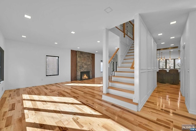 stairway with a fireplace and hardwood / wood-style floors