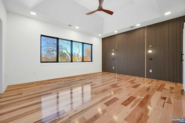 spare room featuring ceiling fan, light hardwood / wood-style floors, and a tray ceiling