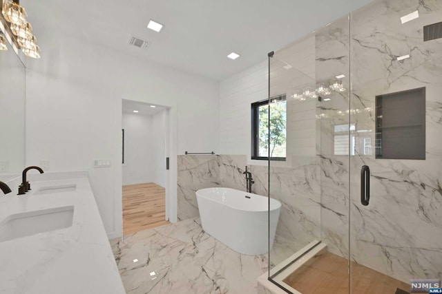 bathroom with separate shower and tub, sink, and tile walls