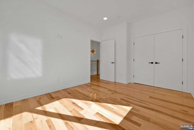 unfurnished bedroom featuring a closet and light hardwood / wood-style flooring