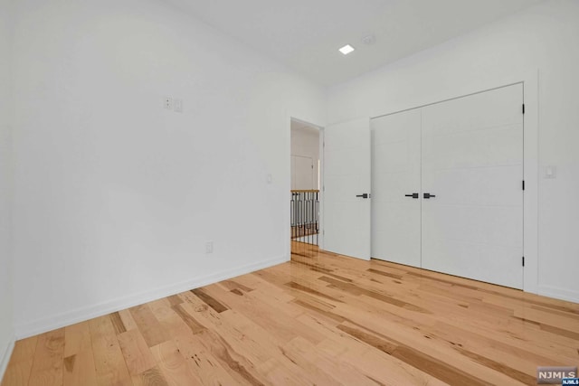 unfurnished bedroom with a closet and hardwood / wood-style flooring