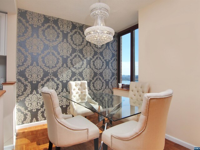 dining room featuring a water view, a chandelier, and parquet flooring