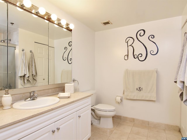 bathroom with tile patterned flooring, vanity, and toilet