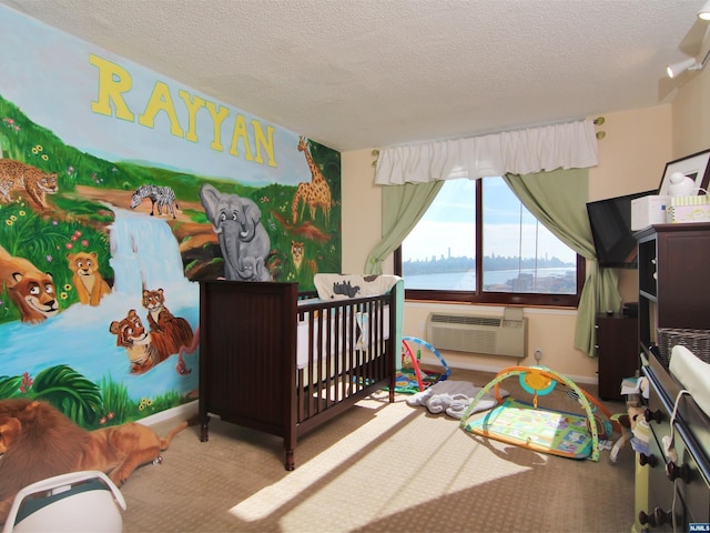 carpeted bedroom featuring a wall mounted AC, a textured ceiling, a water view, and a nursery area