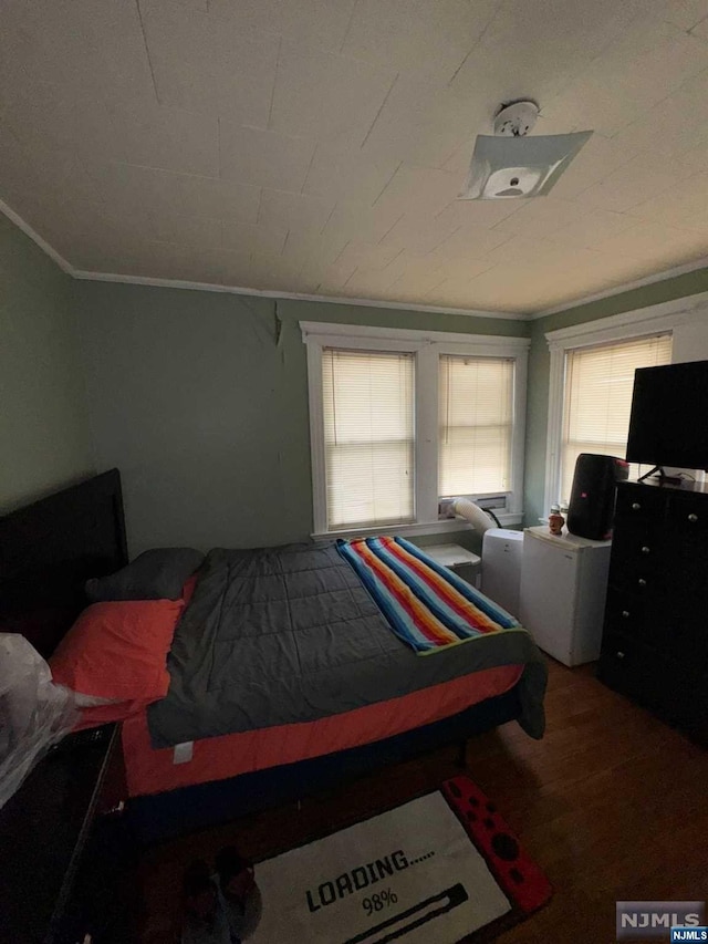 bedroom with hardwood / wood-style floors and crown molding