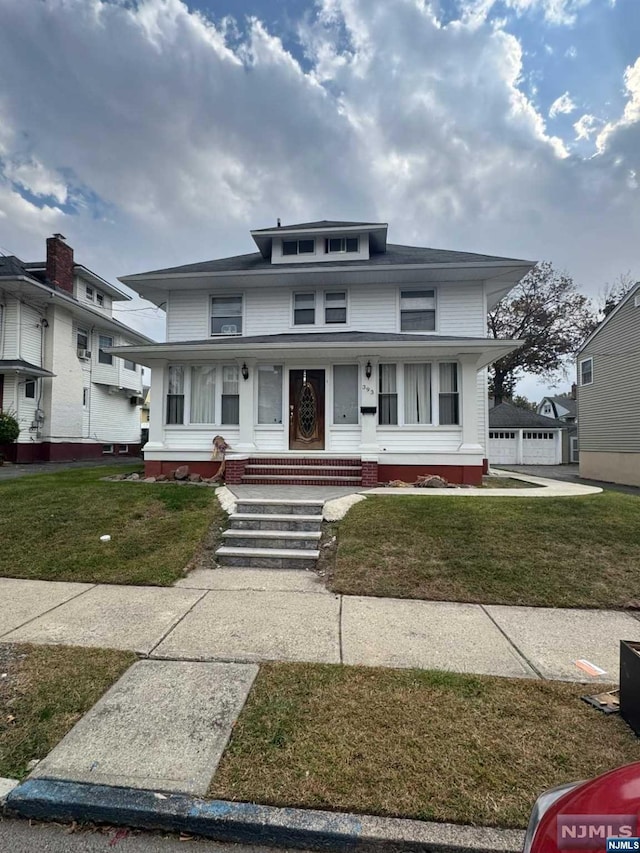 view of front of house featuring a garage, covered porch, an outdoor structure, and a front yard