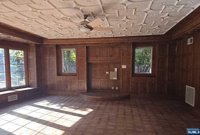 miscellaneous room featuring wood walls and a healthy amount of sunlight