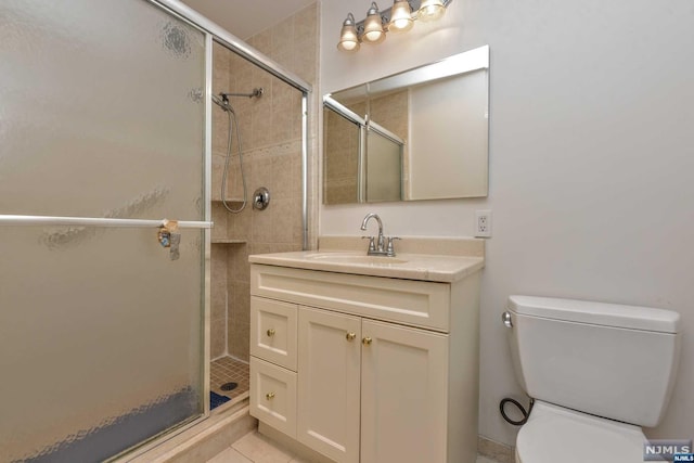 bathroom with tile patterned flooring, vanity, an enclosed shower, and toilet