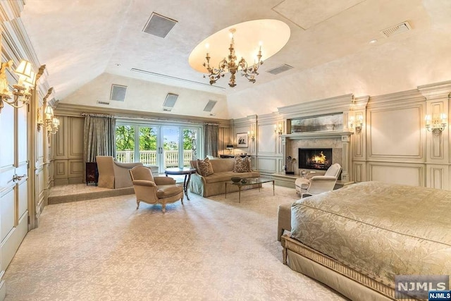 carpeted bedroom with crown molding, a high end fireplace, lofted ceiling, and a notable chandelier