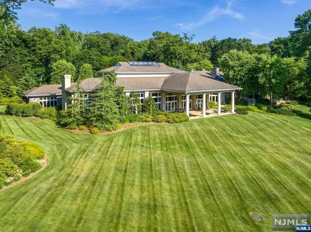 rear view of property featuring a yard