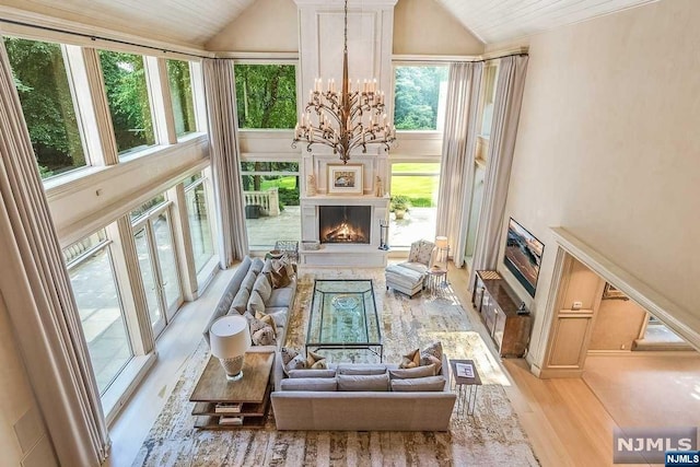 living room with wood ceiling, a chandelier, a healthy amount of sunlight, and light wood-type flooring