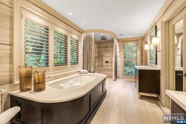 bathroom with vanity, plenty of natural light, plus walk in shower, and hardwood / wood-style flooring