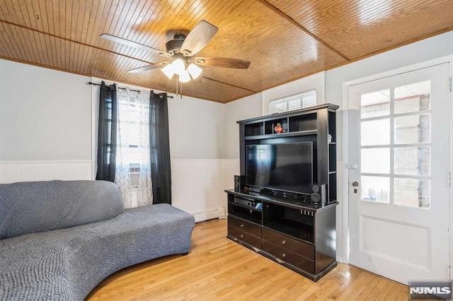 living room featuring plenty of natural light, light wood-type flooring, wooden ceiling, and a baseboard radiator