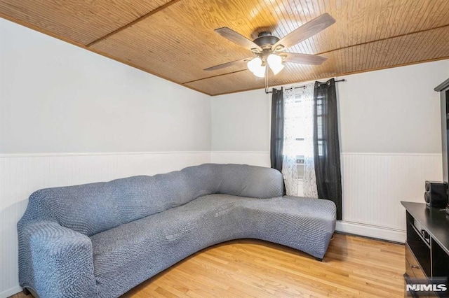 living room with hardwood / wood-style flooring, ceiling fan, a baseboard heating unit, and wood ceiling