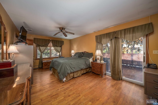 bedroom featuring ceiling fan, a baseboard radiator, light hardwood / wood-style floors, and access to outside