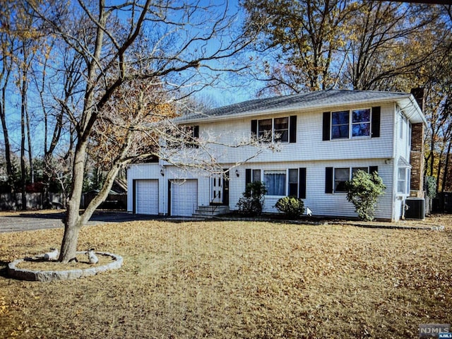 view of front of property with a garage and cooling unit