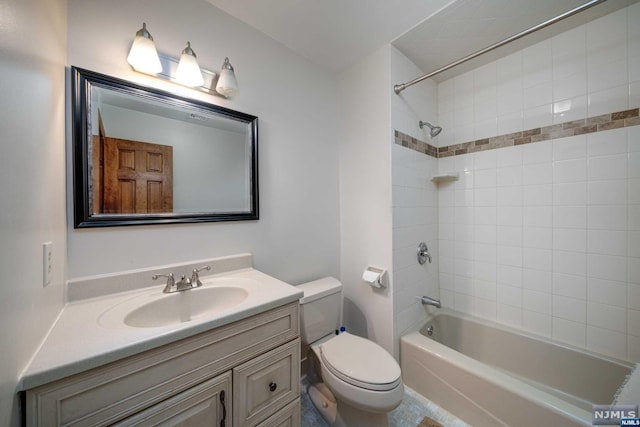 full bathroom with vanity, tiled shower / bath, and toilet