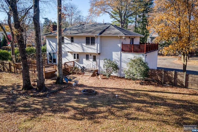 rear view of property with an outdoor fire pit and a deck