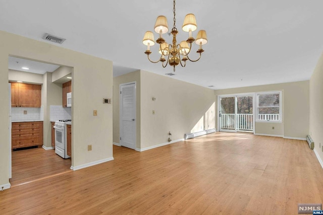 unfurnished living room featuring light wood-type flooring, an inviting chandelier, and a baseboard heating unit