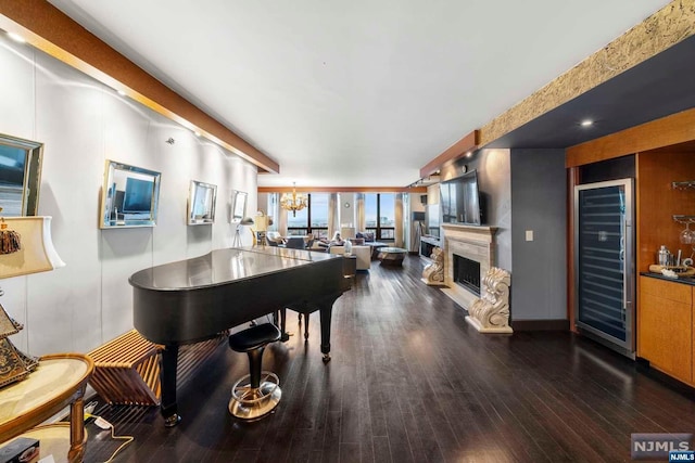 misc room featuring a chandelier, beverage cooler, and dark wood-type flooring