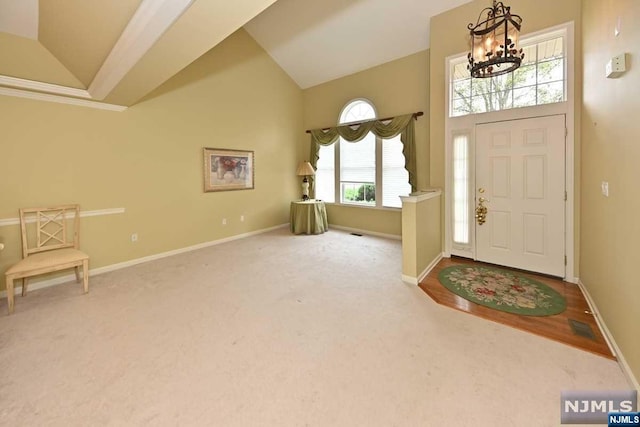 entryway with a chandelier, lofted ceiling, and a healthy amount of sunlight