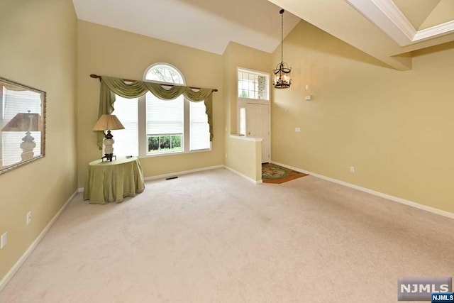 interior space with carpet floors, lofted ceiling, and an inviting chandelier