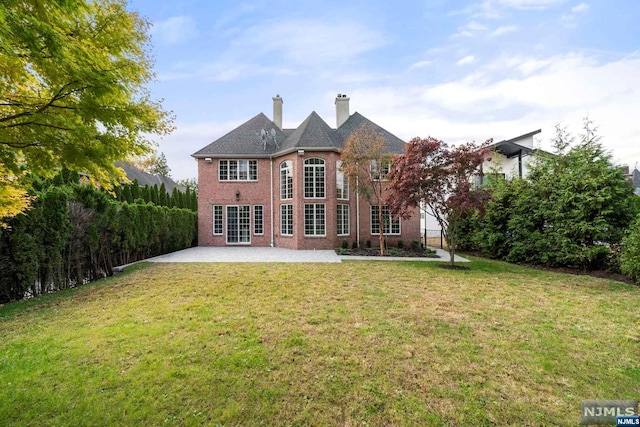 rear view of property featuring a patio area and a lawn