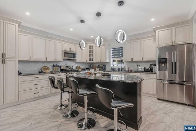 kitchen with pendant lighting, a breakfast bar, a center island, ornamental molding, and stainless steel appliances