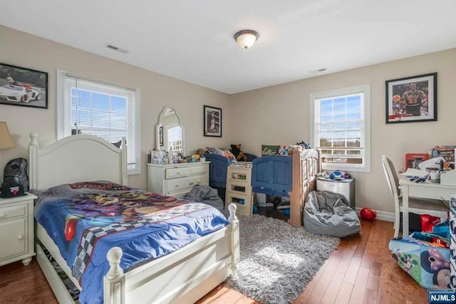 bedroom with dark wood-type flooring and multiple windows