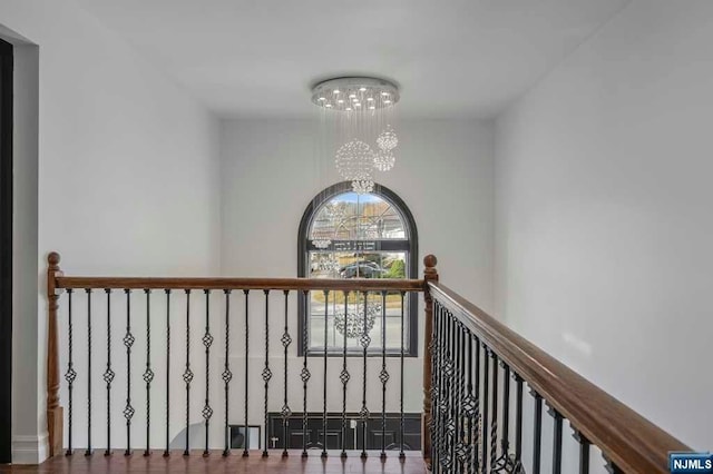 corridor featuring a chandelier and hardwood / wood-style flooring