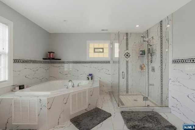 bathroom featuring separate shower and tub, a wealth of natural light, and tile walls