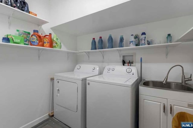 washroom with cabinets, sink, and washer and dryer